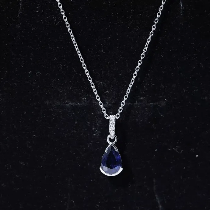 1 CT Pear Cut Blue Sapphire Solitaire Pendant in Half Bezel Setting with Diamond Accent Bail