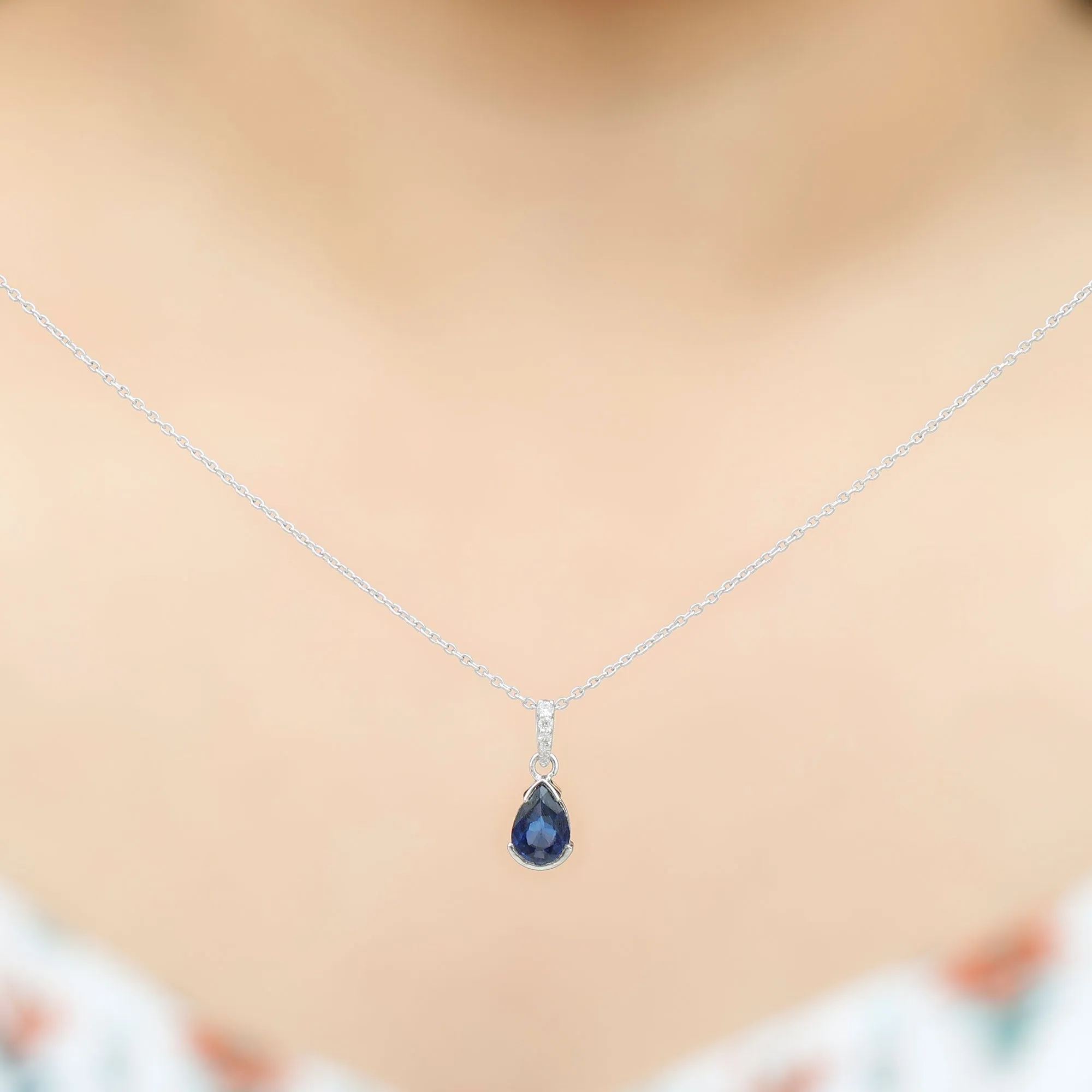 1 CT Pear Cut Blue Sapphire Solitaire Pendant in Half Bezel Setting with Diamond Accent Bail